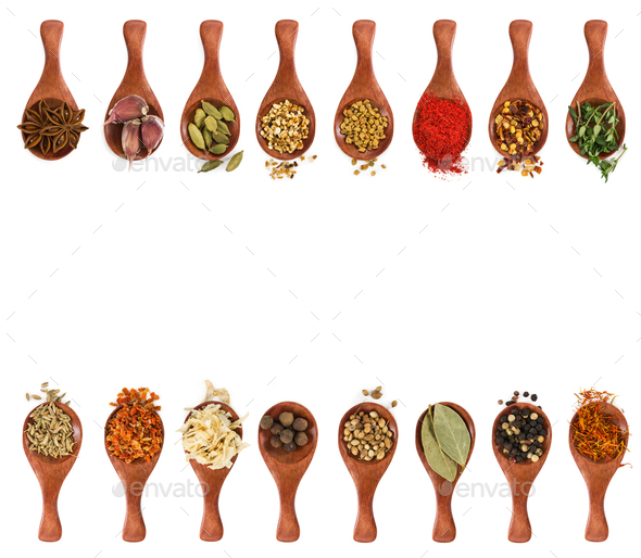 Different seasonings and spices in wooden spoons Stock Photo by